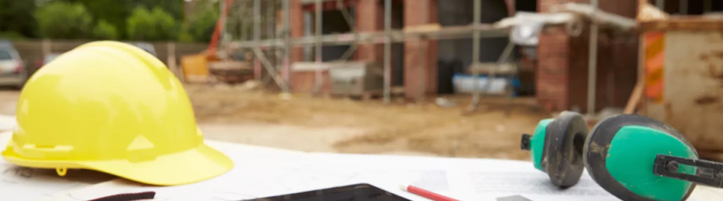 tableta y casco en un sitio de construcción al aire libre