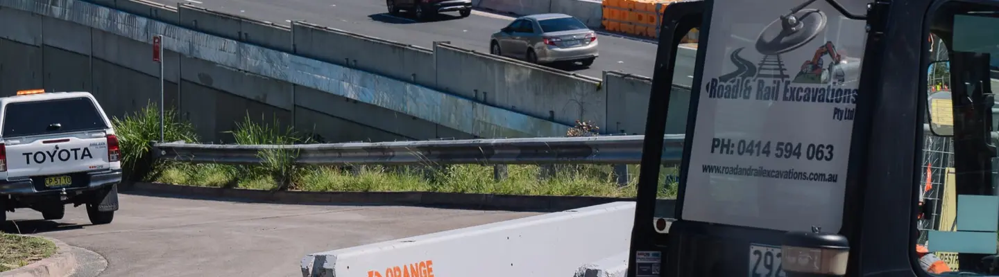 Diversos tipos de barreras de seguridad en carretera instaladas a lo largo de una autopista para proteger a los conductores y peatones.