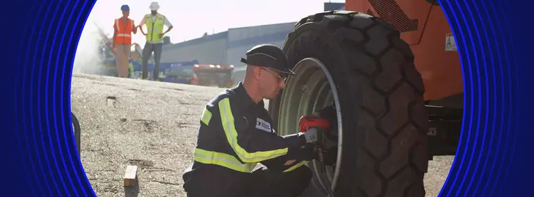 Empleado de United Rentals trabajando con ruedas para un brazo de elevación