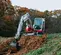 Miniexcavadora Takeuchi roja y blanca con oscilación trasera reducida