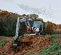 Miniexcavadora Takeuchi roja y blanca con oscilación trasera reducida