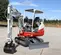 Miniexcavadora Takeuchi roja y blanca con oscilación trasera reducida