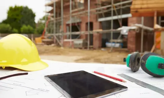 tableta y casco en un sitio de construcción al aire libre