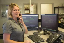 woman standing by desk talking on phone