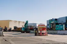 A variety of construction machines parked on the ground, illustrating diverse equipment used at a building site.