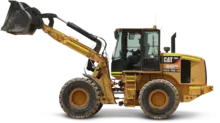 Man driving a backhoe across a construction site, with safety barriers and equipment visible in the background.