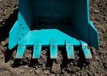 A drum roller compacting soil on a construction site to prepare a stable surface for building or roadwork.