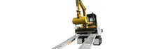 A compact excavator positioned on a trailer ramp, ready for loading or transport against a plain background.
