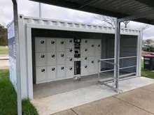 Shipping container modified into a locker facility, with individual locker doors visible along the container’s interior walls.
