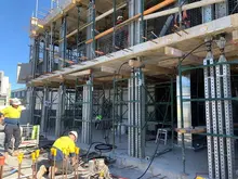 Workers installing temporary supports and braces at a construction site to stabilize structures during the building process.